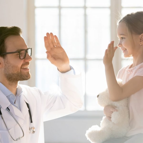 Friendly,Male,Pediatrician,Giving,High,Five,To,Little,Patient,Close