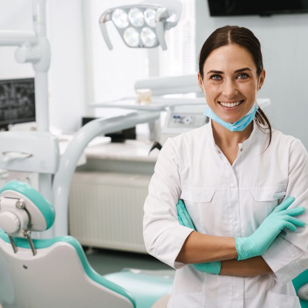 European,Mid,Dentist,Woman,Smiling,While,Standing,In,Dental,Clinic